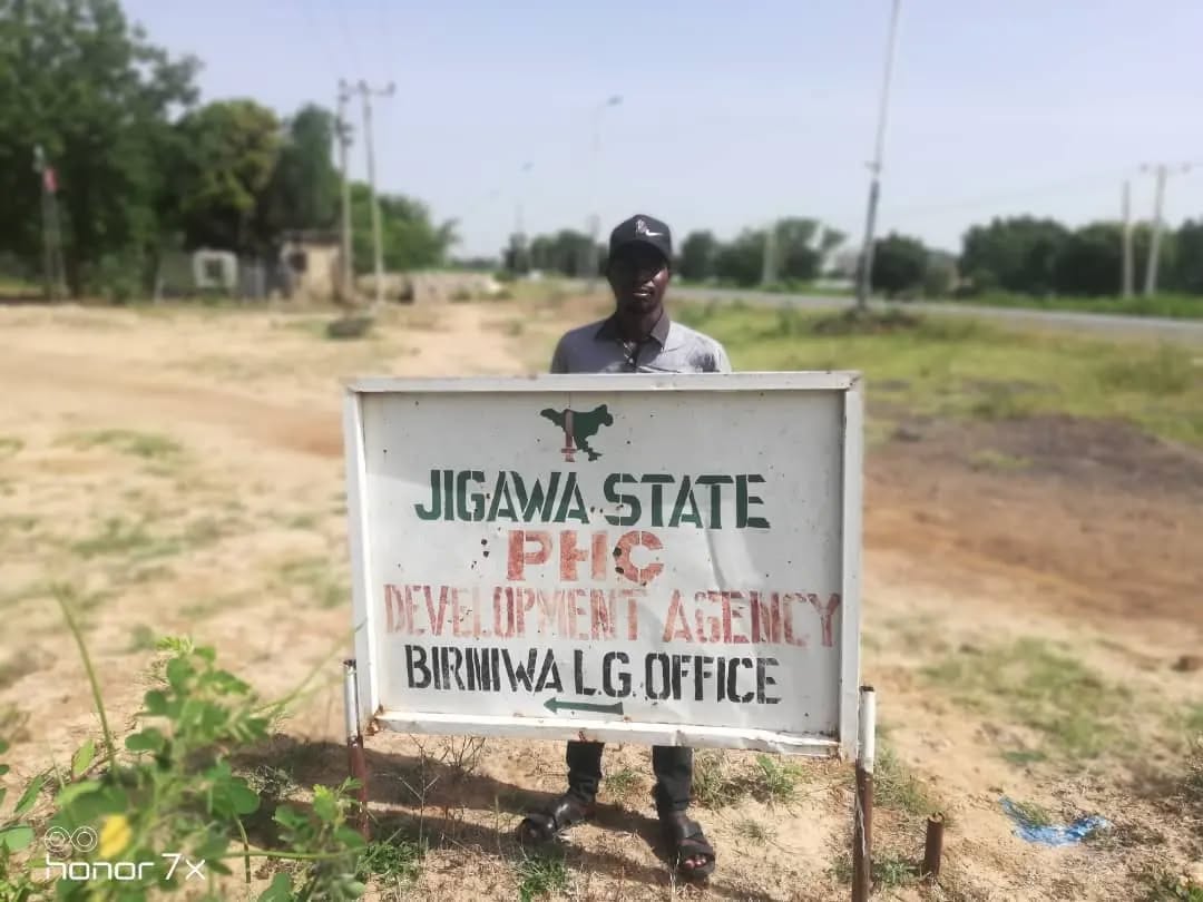 Man standing behind signpost